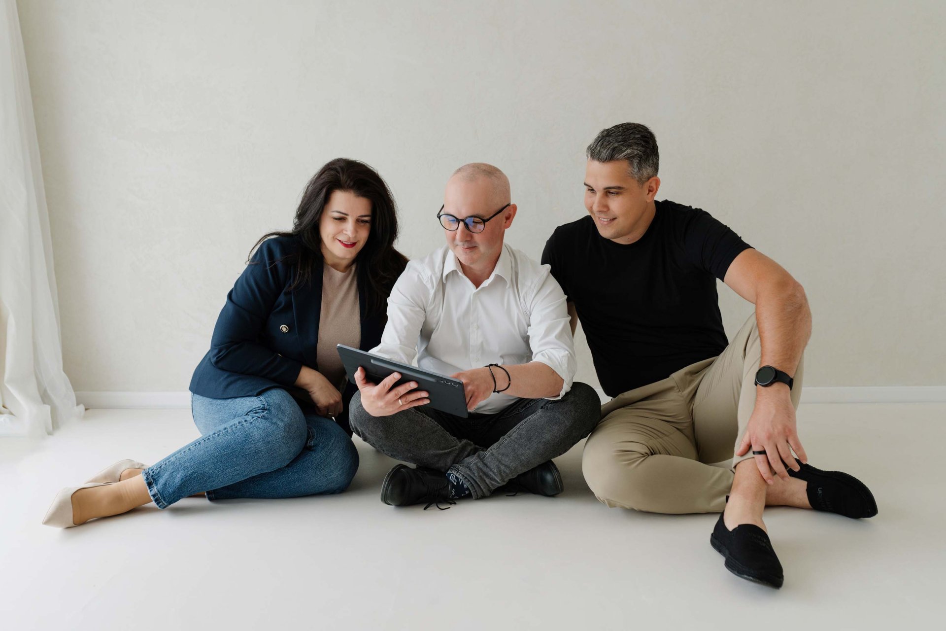 Náš tím sediaci vedľa seba v trojici. Líder tímu Norbert v rukách drží tablet a radí sa ohľadne dát s prísediacou Beátou a Markom.